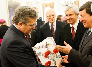 B. Komorowski, polnischer Präsident (links) erhält von der adventistischen Delegation ein Geschenk