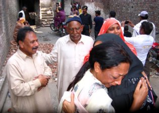 Adventistischer Pastor Afzal Bhatti (hinten links) mit Frau Parveen (vorne Mitte) trösten Kirchenmitglieder