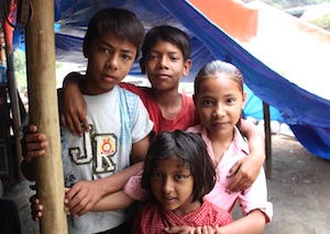 Kinder in Nepal unter einer Zeltplane, ihrer provisorischen Behausung