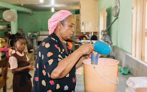 Melva Robinson giesst Saft für eines der Dutzenden Schulkinder in ihrer Suppenküche ab 