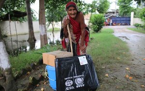 Nepalesin mit Hilfsgütern von ADRA