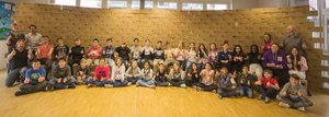 Schüler und Schülerinnen mit den Lehrpersonen vor der Wand mit 408 Weihnachtspaketen