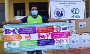 ADRA-Mitarbeiter mit Gesundheitsbanner informiert im Bezirk Preah Vihear über beste Hygienepraktiken