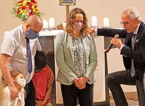 Pastorin M. Ostrovljanovic kniet mit Familie und W. Dorn (re.), Präsident der Adventisten in Bayern, bei der Segnungshandlung