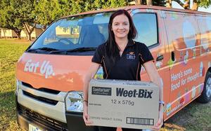 Mitarbeiterin des Hilfswerks Eat Up mit einem Karton des Vollkorn Müsli-Riegels «Weet-Bix»
