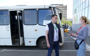 Sergey Marchenko, ADRA Koordinator für soziale Transporte, wird vor Reisebus interviewt