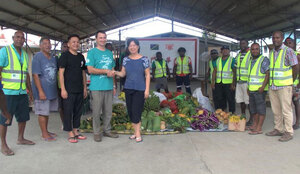 Bei der Übergabe von Lebensmitteln an Vertreter der chinesischen Gemeinschaft auf den Salomonen.