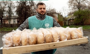 Freiwilliger von ADRA Ukraine hilft bei Brotverteilung.