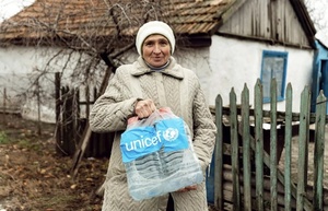 Die Bewohnerin einer Siedlung in der Ukraine hat Trinkwasser erhalten.