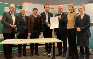 Nach der Unterzeichnung halten Thomas Wüstner (Vivantes Klinikum) und Bernd Quoss (Krankenhaus Waldfriede) v.l. das Dokument.