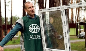 ADRA-Helfer beim Einbau neuer Fenster in beschädigten Gebäuden in der Ukraine.