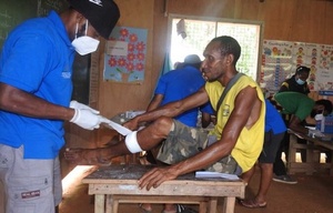 Japheth Kerowa, Medizinstudent im ersten Jahr, verbindet die Wunde am Bein eines Patienten.