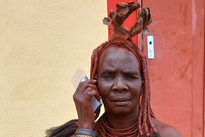 Eine Frau aus dem Volk der Ovahimba hört biblische Texte auf einem solarbetriebenen Audioplayer.