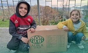 Adam (li.) und seine Schwester mit einem Lebensmittelpaket von ADRA Syrien. 