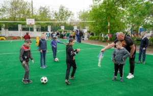 Schüler der Sonderschule Nr. 3 in Mykolaiv freunden sich am Eröffnungstag mit dem Fussballplatz an.
